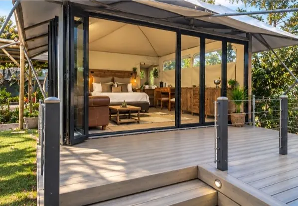 Glamping suite with folding glass doors opening onto a garden deck