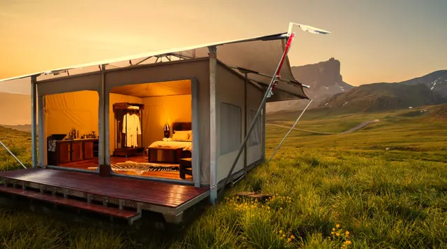 Glamping tent with open canvas front on a raised deck in open grassland